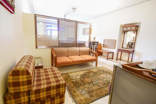 a living room with a couch and a window at Hotel Meghniwas in Jaipur