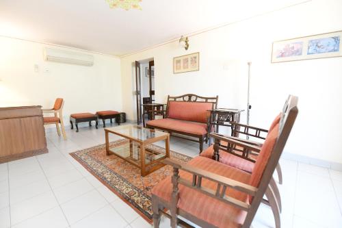 a living room with wooden furniture and a piano at Hotel Meghniwas in Jaipur