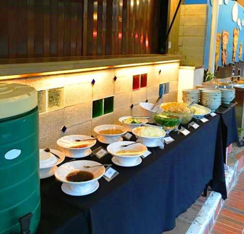 a table with bowls and plates of food on it at Master Bear Resort in Jiafeng