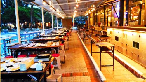 a restaurant with a long line of tables with food at Master Bear Resort in Jiafeng
