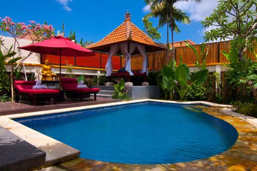 a swimming pool in a yard with a gazebo at The Awan Villas - CHSE Certified in Seminyak