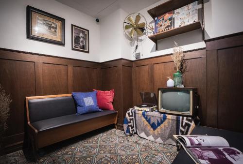 een woonkamer met een bank en een tv bij Mojo Old Town Phranakorn in Bangkok
