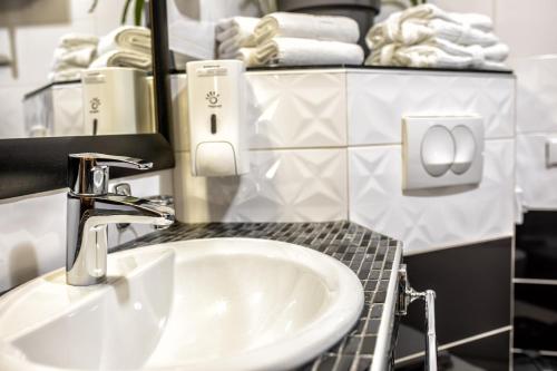 a bathroom with a sink and a mirror and towels at F Apartmani Kragujevac in Kragujevac