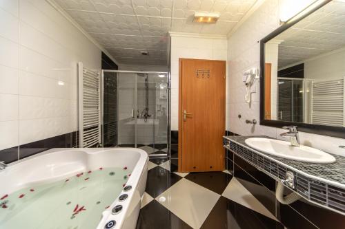 a bathroom with a tub and a sink at F Apartmani Kragujevac in Kragujevac