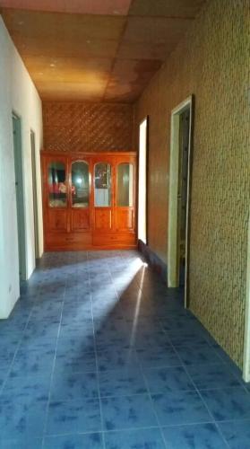 an empty room with wooden doors and a tile floor at SHUKRAN Apartelle in Siquijor