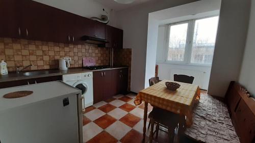 Il comprend une cuisine équipée d'une table, d'un évier et d'une cuisinière. dans l'établissement Apartment Na Saharova, à Ivano-Frankivsk