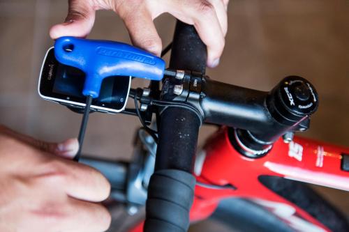 a person is attaching a cell phone to a bike at Curolla Petit Hotel in Maria de la Salut