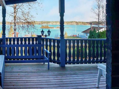 a blue bench on a porch with a view of the water at 4 person holiday home in SÖDERKÖPING in Söderköping