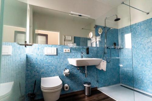 ein Bad mit einem WC, einem Waschbecken und einer Dusche in der Unterkunft Privathotel Stickdorn in Bad Oeynhausen
