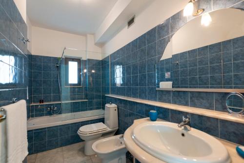 a blue tiled bathroom with a sink and a toilet at Atlantis Palace Hotel in Mascali