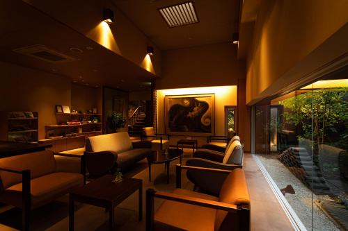 a lobby with couches and tables and a painting at Migiwaya in Yaizu