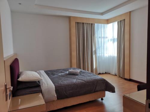 a bedroom with a bed and a large window at Bernard Holiday Home 2 @ Boulevard Imperial Suite Kuching in Kuching