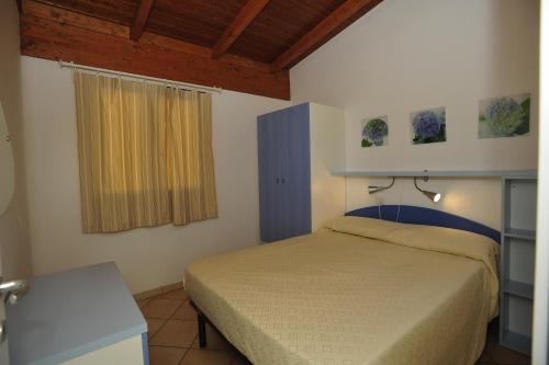 a small bedroom with a bed and a window at Camping Terrazzo sul mare in Cupra Marittima