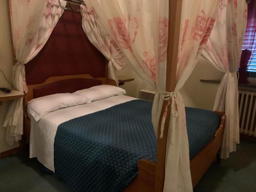 a bedroom with a bed with a canopy at Hotel Ficocle in Cervia