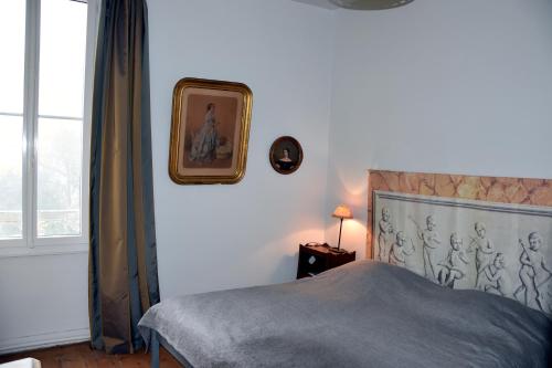 FléacにあるLes Hirondellesのベッドルーム1室(ベッド1台付)が備わります。壁に絵が飾られています。