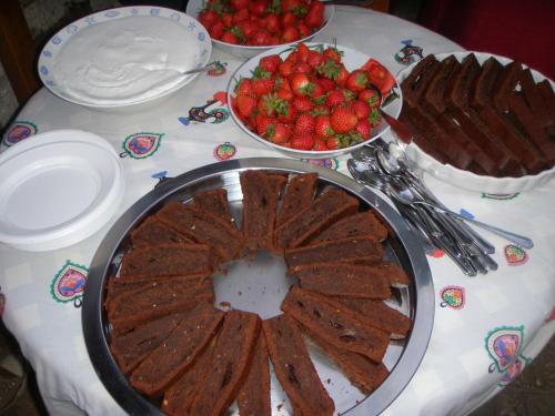 a table with a cake and strawberries on it at Unique Tiny House with Natural Building Techniques in Figueiró dos Vinhos