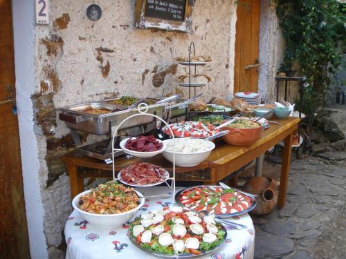 a buffet of food on a table with plates of food at Unique Tiny House with Natural Building Techniques in Figueiró dos Vinhos