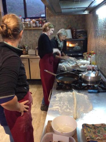 two women standing in a kitchen preparing food at Unique Tiny House with Natural Building Techniques in Figueiró dos Vinhos