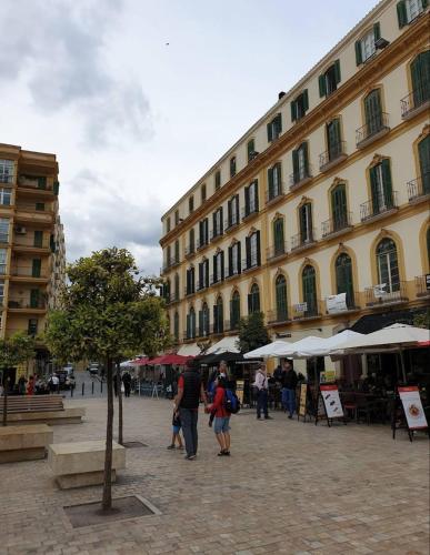a group of people walking past a large building at La Casa de La Abuela Rosy in Málaga