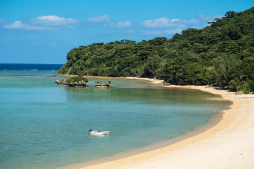 a boat in the water next to a beach at Hotel Hoshitate Iriomotejima in Iriomote