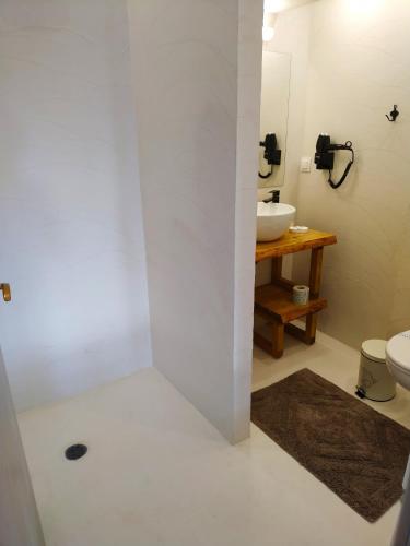 a white bathroom with a sink and a toilet at Oasi in Kato Loutraki