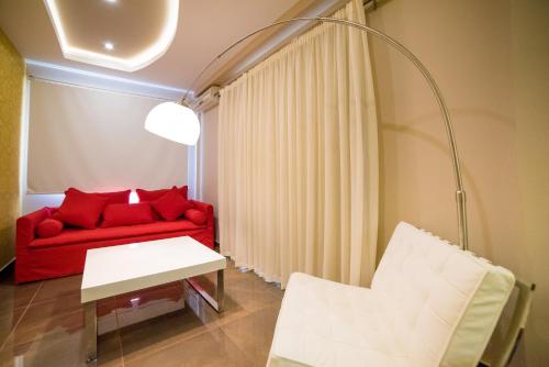 a red couch with red pillows in a living room at Koukounaria Hotel & Suites in Alykes