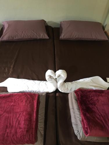 a bed with two pillows in the shape of a heart at Thong Family Homestay Chiangdao in Chiang Dao