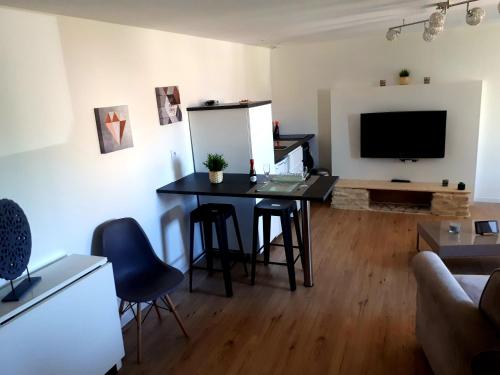ジョネ・クランにあるFuturoscope appartement 40m2 à 7 min du parcのテーブルとテレビのあるリビングルーム