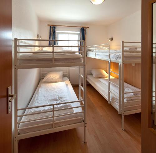 a room with three bunk beds and a window at Residenz Monica Top 6 in Sankt Margarethen im Lungau