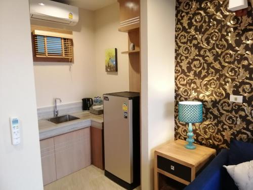 a small kitchen with a refrigerator and a sink at Khaolak Blue Sky Villa in Khao Lak