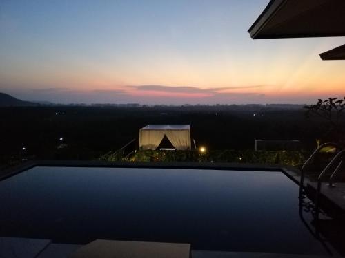 a sunset over a swimming pool with a tent at Khaolak Blue Sky Villa in Khao Lak
