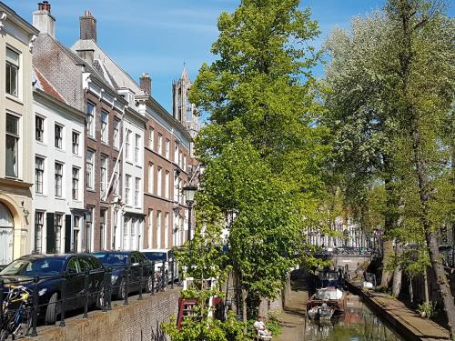 a city street with buildings and a canal with cars at Large Historical Apartment & Canal Terrace in Utrecht