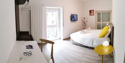 拉奎拉的住宿－Via Roma，卧室配有1张床、1张桌子和1把椅子