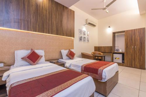 una habitación de hotel con 2 camas en una habitación en Rupam Hotel, en Nueva Delhi