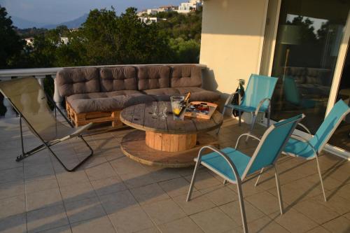 a patio with a couch and chairs and a table at Sole Rossu in Albitreccia