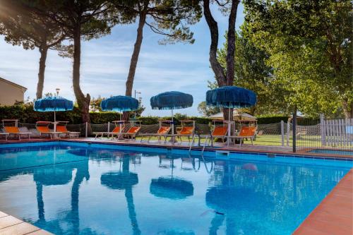 una piscina con sillas y sombrillas en Hotel Frank en Lido di Jesolo