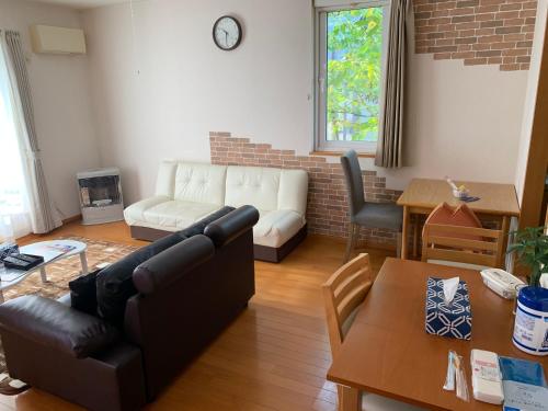 a living room with a couch and a table at Sejour Toyohirakoen in Sapporo