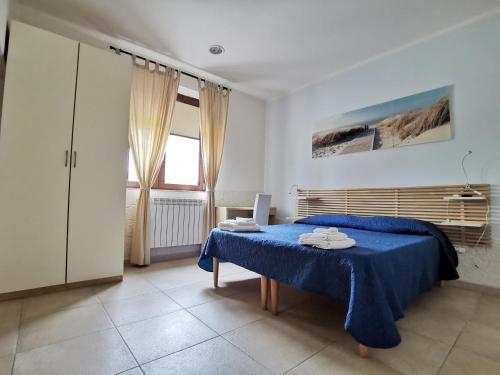 Un dormitorio con una cama azul y una ventana en B&B Dimora Mariù, en Taranto