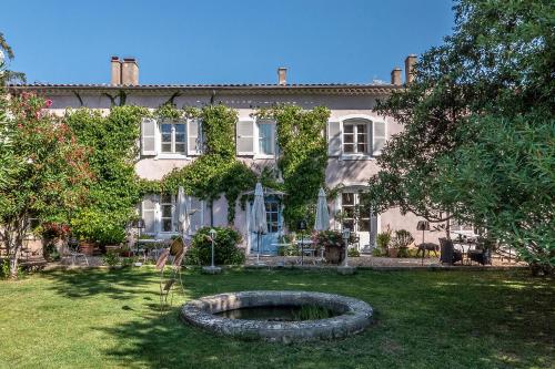 une maison avec un grand pneu dans la cour dans l'établissement Mas d'Escattes, à Nîmes