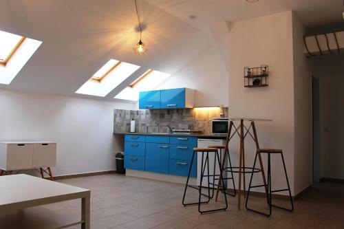 une cuisine avec des placards bleus et des tabourets. dans l'établissement Urban-Style-Rooftop-Apartment, à Vienne