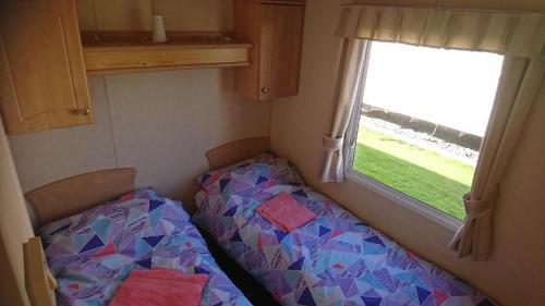 mały pokój z łóżkiem i oknem w obiekcie Clwyd 40 Vacation w mieście Borth