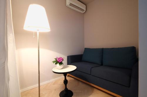 a living room with a blue couch and a table with a lamp at Panonija in Kotor