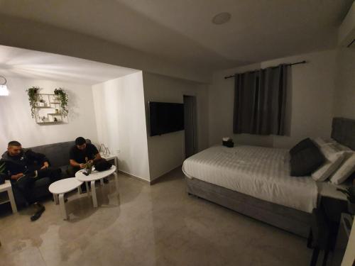 zwei Männer auf einer Couch in einem Hotelzimmer in der Unterkunft The boutique in Jerusalem