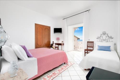 una camera con due letti e un tavolo con televisore di Hotel Smeraldo a Praiano
