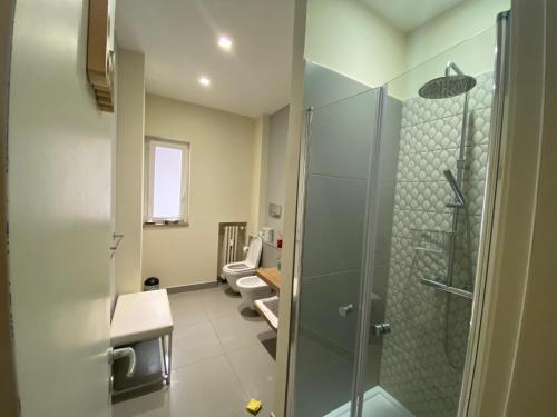 La salle de bains est pourvue de 2 toilettes et d'une douche en verre. dans l'établissement 70's Luxury Cavour, à Bari