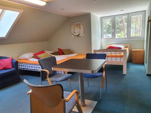 a room with two beds and a table and chairs at Freedom65 Hostel and Caravan in Tallinn