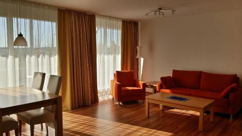 salon z czerwoną kanapą i stołem w obiekcie 2-Zi. Luxus Appartement mit Bademantelgang zur Wohlfühltherme w mieście Bad Griesbach