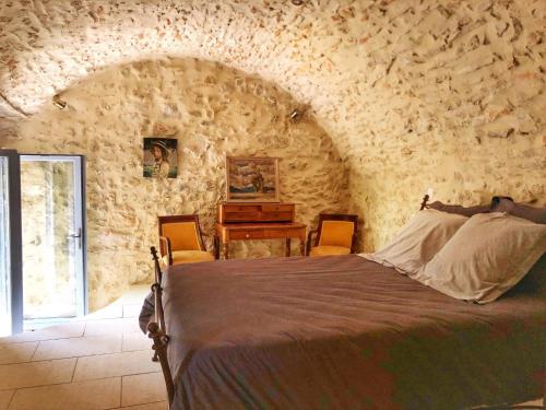LussanにあるLa Magnanerie d'Audabiacの石壁のベッドルーム1室