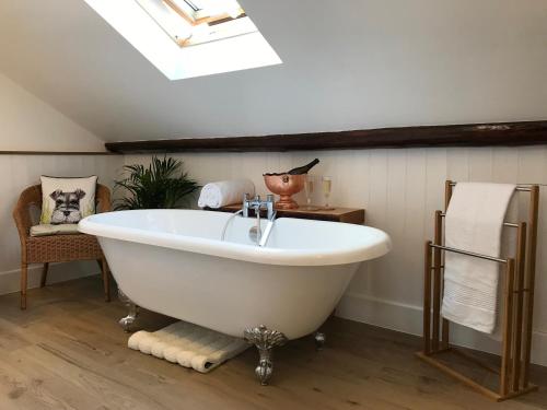 a white bath tub in a bathroom with a skylight at Luxurious Townhouse in the Heart of Champagne in Épernay