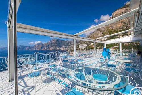 a balcony with chairs and tables on a cruise ship at Hotel Smeraldo in Praiano